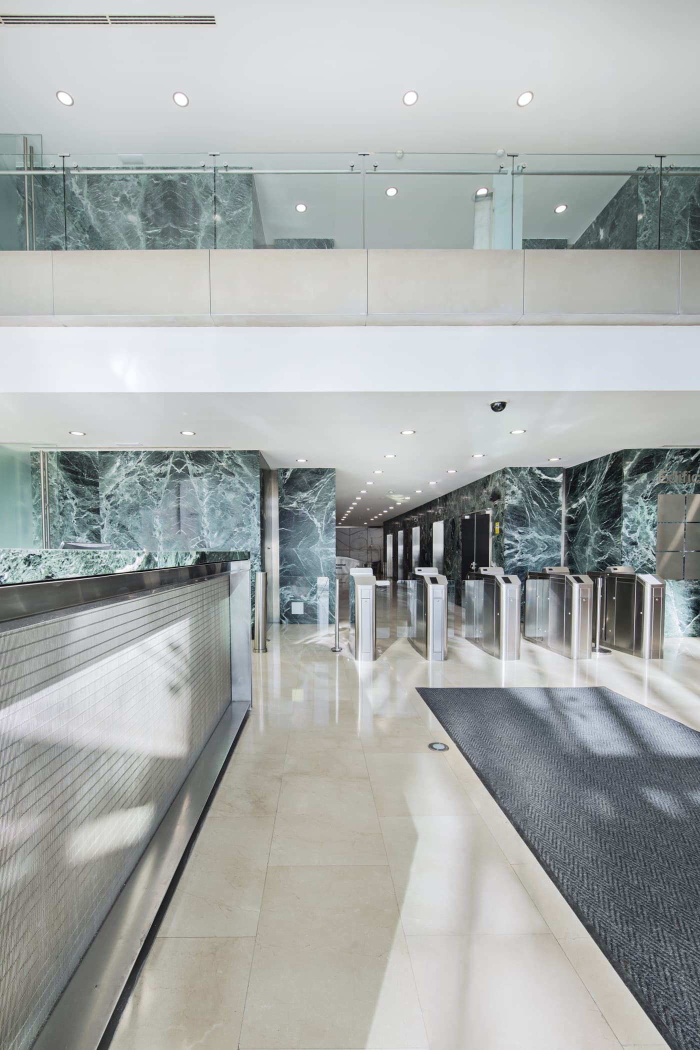 Marble office atrium with access-control turnstiles at the entrance